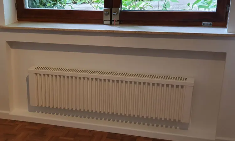 Une femme met ses mains sur un radiateur